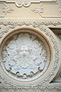 A fragment of a coffered ceiling in a historic building with a stucco decoration in the form of a Dionysus mask.