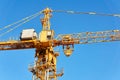 Fragment of a construction tower crane with a cabin against a blue sky Royalty Free Stock Photo