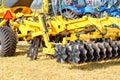 A fragment of the coupling of a multi-row disc harrow with a tractor on a summer day