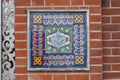 Fragment of the decoration of the facade of an old building in the form of ceramic tiles with a geometric pattern