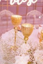 Fragment Decoration of wedding table with composition of white roses, gypsophila, gold candlesticks.