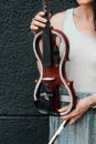 A fragment of an electric violin, a violin in the hands of a musician's girl.