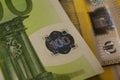 A fragment of a 100 euro banknote with a hologram. Eurozone currency fragment.