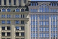 Fragment of the facade of a high-rise multi-story building with many glass windows reflecting blue sky. Royalty Free Stock Photo