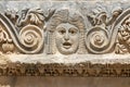 Fragment of the facade with the image of stone masks of the Greco-Roman amphitheater of the ancient city of Myra in Demre