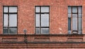 Fragment of the facade of an old brick building. High Windows and textural materials