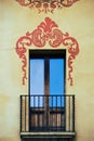 Fragment of the facade of an old house with a door, a window, a small balcony and a beautiful pattern on the wall Royalty Free Stock Photo