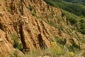 Fragment of the famous Stob Pyramids with unusual shape red and yellow rock formations, green bushes and trees around