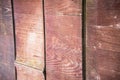 A fragment of a fence made of old brown polished boards and planks.Old wooden surface.Texture, background, close up Royalty Free Stock Photo