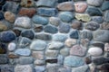 A fragment of a fence of round stones and cement ligaments. Background, texture. Landscape
