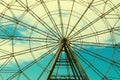 Fragment of Ferris wheel against the background of blue sky and white clouds. Vintage Filter Royalty Free Stock Photo