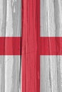 Fragment of the flag of England on a dry wooden surface, cracked with age. It seems to flutter in the wind. Vertical background Royalty Free Stock Photo