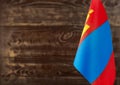 Fragment of the flag of Mongolia in the foreground blurred wooden background Kopi space