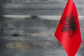 Fragment of the flag of the Republic of Albania in the foreground blurred wooden background place under the text