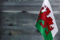 Fragment of the flag of Wales in the foreground blurred wooden background place under the text