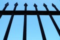 Fragment of a forged fence against the background of the clear sky, bottom view Royalty Free Stock Photo