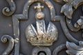 Fragment of a forged metal door with a crown ornament with a cross. Black color. Religious design. The symbol of power. Close-up