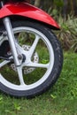 Fragment of front wheel with disc brakes of a red scooter. Royalty Free Stock Photo