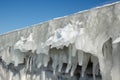 Fragment of a frozen breakwater wall with icicles