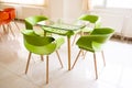 Fragment of interior cafe with bright red, green tables and plastic chairs