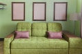 Fragment of the interior with a green sofa and picture cards Royalty Free Stock Photo