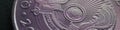 Fragment of Kazakh 50 tenge coin with the country emblem and focus on shanyrak. Closeup. Light violet tinted header or banner for