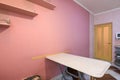 Fragment of kitchen interior, dining table and part of a painted wall with shelves Royalty Free Stock Photo