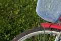 Fragment of a ladies` bicycle in red and white color. Stands in the park on the lawn. Close-up shot