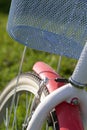 Fragment of a ladies` bicycle in red and white color. Stands in the park on the lawn. Close-up shot