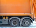 Fragment of a large garbage disposa. Orange bunker or garbage truck body