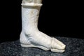 Fragment of a marble sculpture depicting a woman\'s legs in beautiful shoes. Art and architecture of the ancient world