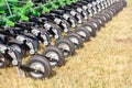 Fragment of the mechanism of a multirow seeder on pneumatic wheels against the background of an agricultural field Royalty Free Stock Photo