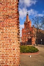 Fragment of a medieval defensive wall and red brick buildings Royalty Free Stock Photo