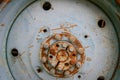 Fragment of metal old car wheel with rusty bolts, close-up. Out - of-order agricultural machinery, recycling of broken mechanisms Royalty Free Stock Photo