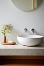 Fragment of minimalist bathroom with white wall, Terrazzo stone countertop, white sink, wall mounted faucets and elegant