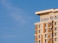 Fragment of modern beige multi-storey residential building against blue sky. Close-up. Background for ad or banner Royalty Free Stock Photo