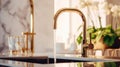 Fragment of a modern classic luxury kitchen. White marble countertop with built-in sink, curved gold faucet with running Royalty Free Stock Photo