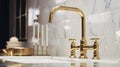 Fragment of a modern classic luxury kitchen. White marble countertop with built-in sink, curved vintage gold faucet Royalty Free Stock Photo