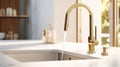 Fragment of modern classic luxury kitchen. White stone countertop with built-in sink, gold faucet with running water Royalty Free Stock Photo