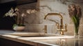 Fragment of a modern luxury kitchen. White marble countertop and backsplash, built-in sink, gold faucet and soap Royalty Free Stock Photo