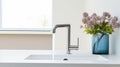 Fragment of a modern luxury kitchen with window on the background. White stone countertop with built-in sink, chrome Royalty Free Stock Photo