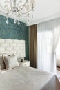 Fragment of modern master bedroom in baroque eclectic style white and blue interior design. Bed with pillows duvet Royalty Free Stock Photo