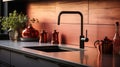 Fragment of modern minimalist kitchen. Gray countertop with built-in sink and metallic faucet. Copper crockery. Peach
