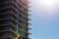 Fragment of modern multi-storey residential building against blue sky. Close-up. Background for ad or banner. Copy space Royalty Free Stock Photo