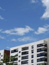 Fragment of modern residential condo buildings exterior. Copy space. Blue sky with vibrant clouds. Vertical photo Royalty Free Stock Photo