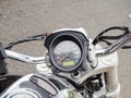 Fragment of a motorcycle steering wheel with a round speedometer. Close-up photo