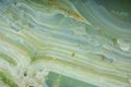 Fragment of natural polished Verde Onyx stone of green color with streaks