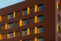 Fragment of a new elite house or residential complex. Part of urban real estate. Windows on a yellow-brown modern