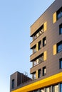 Fragment of a new elite residential building or commercial complex against a blue sky. Part of urban real estate. Yellow
