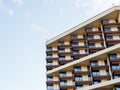 Fragment of a new modern unoccupied house with brown balconies against a blue sky background